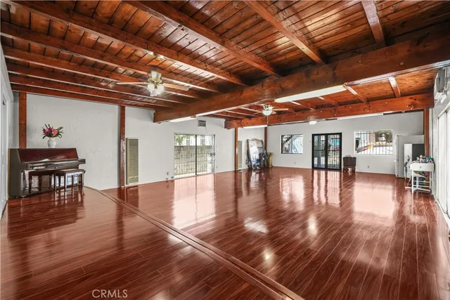 a roof deck with table and chairs with wooden floor