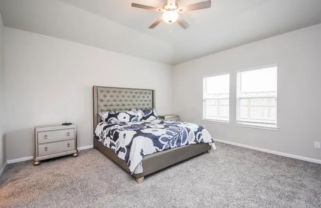 a bed sitting in a bedroom next to a window and a chandelier