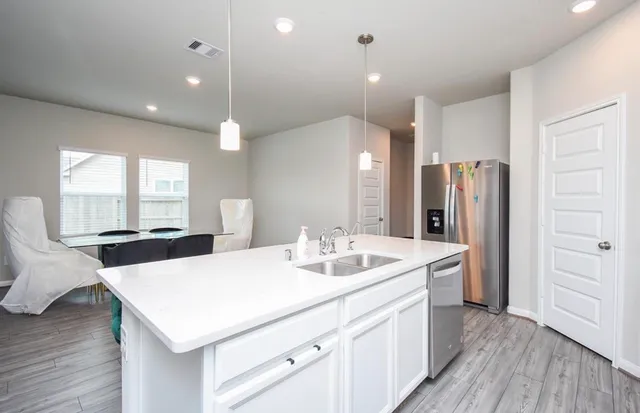 a kitchen with a sink a refrigerator and wooden floor