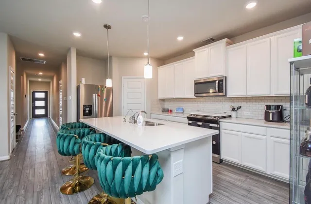 a kitchen with counter top space a sink appliances and cabinets