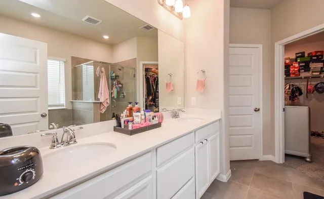 a bathroom with a double vanity sink a vanity and a shower