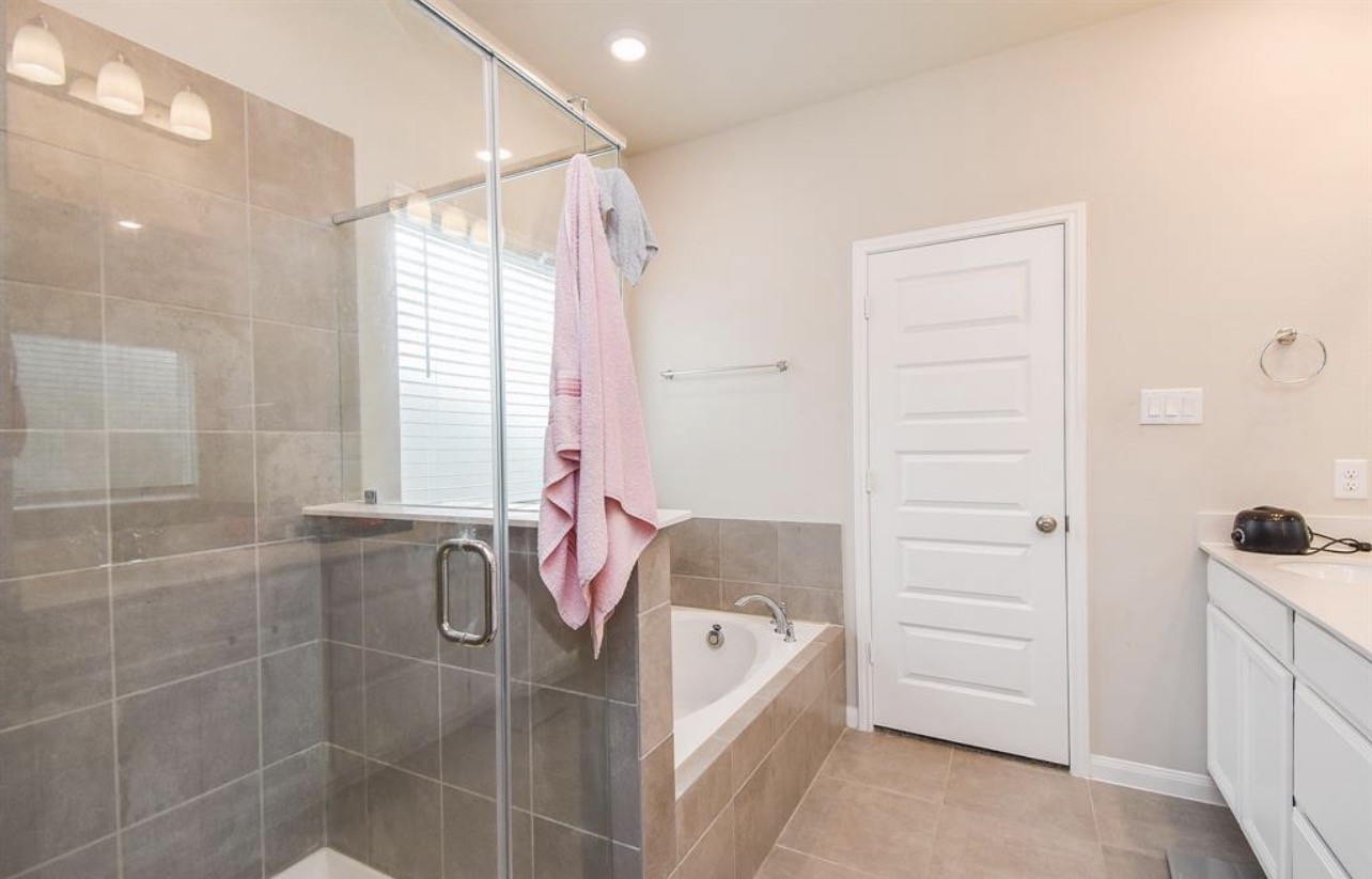 6927 Ventura Drive Rosharon, TX 77583 - Photo 9 of 20 The primary en-suite features both a soaking tub and a separate shower, offering flexibility for relaxation or a quick start to the day. Designed for comfort and convenience, the layout provides a private retreat within the primary suite.
