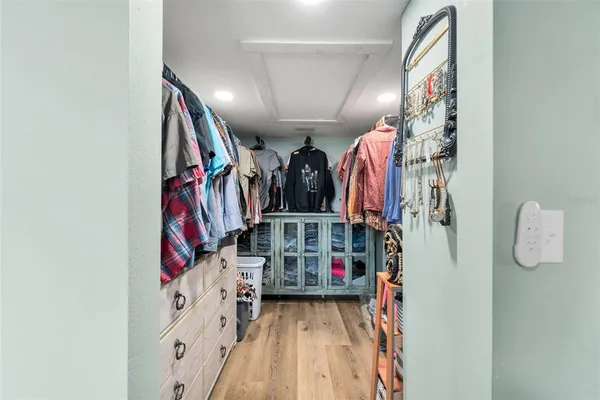 a view of walk in closet with clothes and shoes