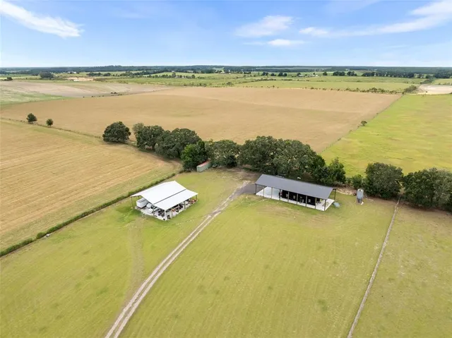 an aerial view of ocean and residential houses with outdoor space
