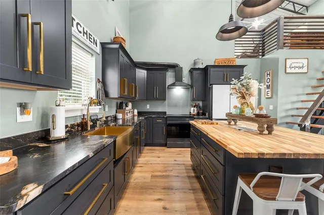 a kitchen with stainless steel appliances granite countertop a sink stove and refrigerator
