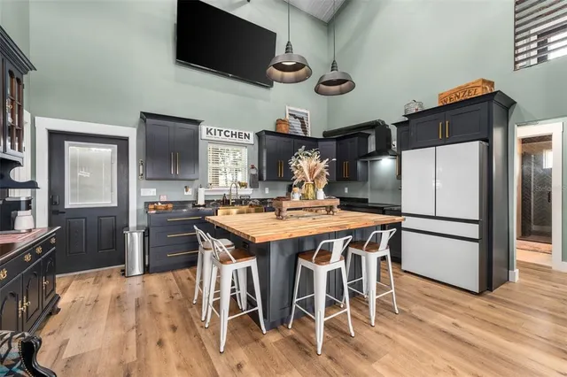 a kitchen with stainless steel appliances a stove a refrigerator a microwave oven a sink with island and chairs