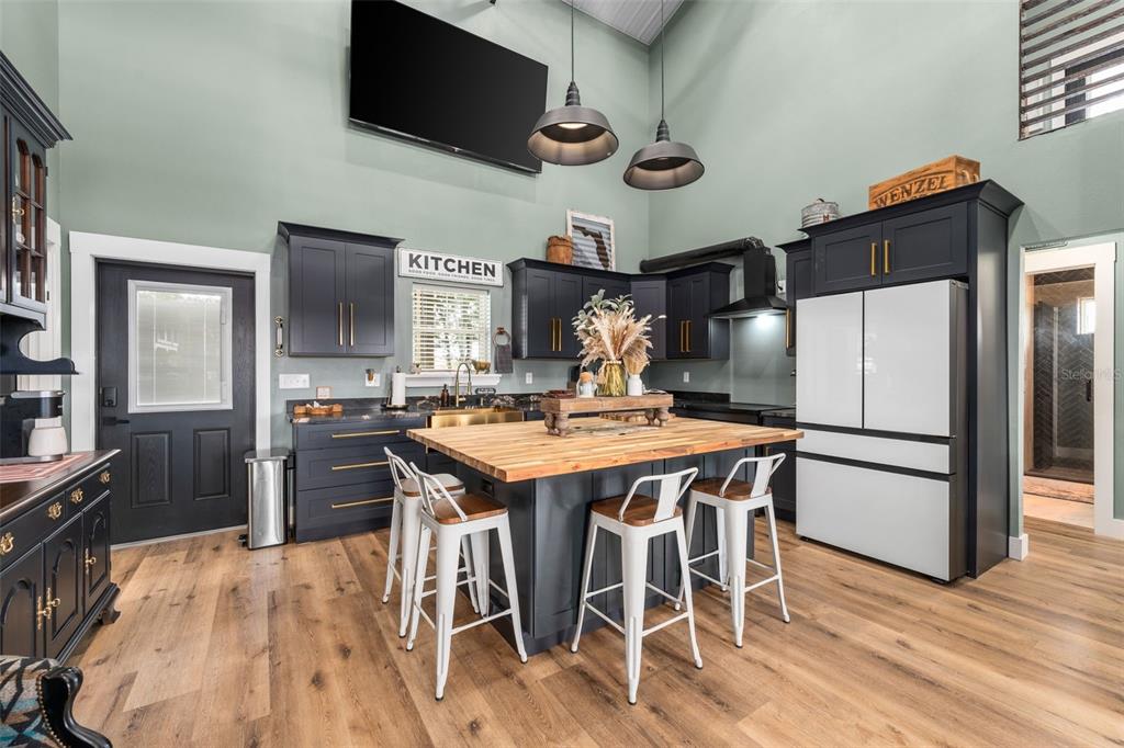 23220 Northwest 27 Street Morriston, FL 32668 - Photo 7 of 44 a kitchen with stainless steel appliances a stove a refrigerator a microwave oven a sink with island and chairs