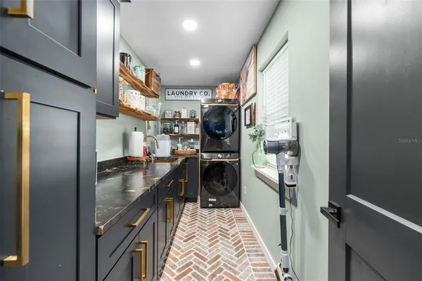a kitchen with stainless steel appliances granite countertop a refrigerator a stove and a sink with wooden floor