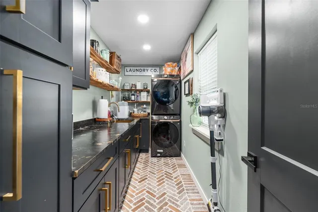 a kitchen with stainless steel appliances granite countertop a refrigerator a stove and a sink with wooden floor