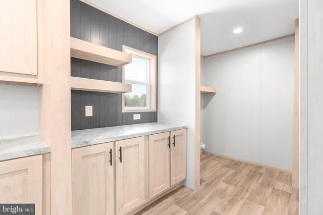 a kitchen with white cabinets and wooden floor