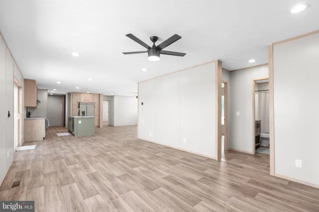 a view of a big room with wooden floor and a ceiling fan