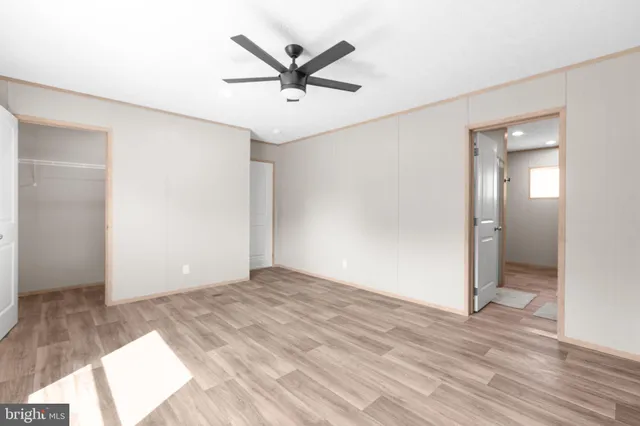 a view of a big room with wooden floor and a ceiling fan