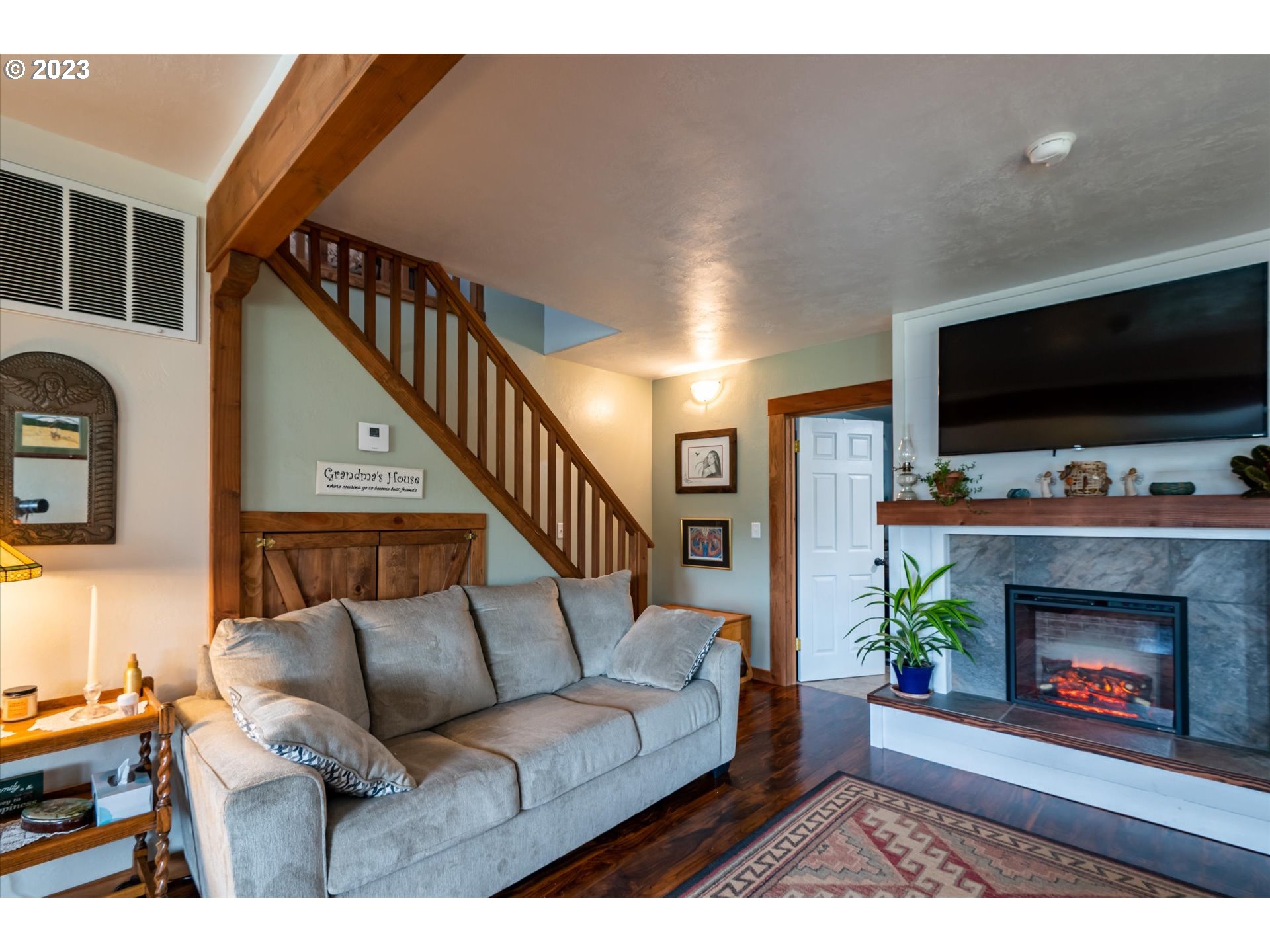 100 South 6th Street Lakeside, OR 97449 - Photo 12 of 42 a living room with furniture a flat screen tv and a fireplace