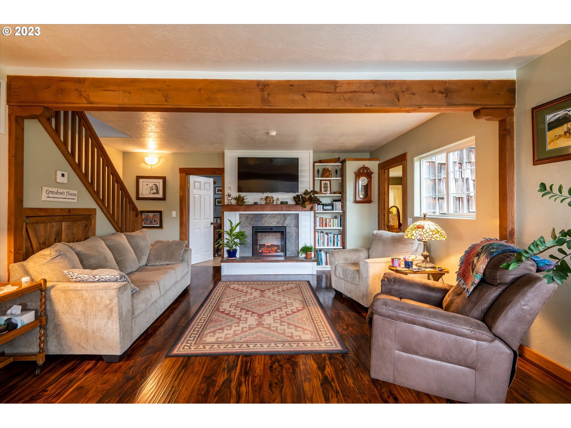 100 South 6th Street Lakeside, OR 97449 - Photo 7 of 42 a living room with furniture a flat screen tv and a fireplace