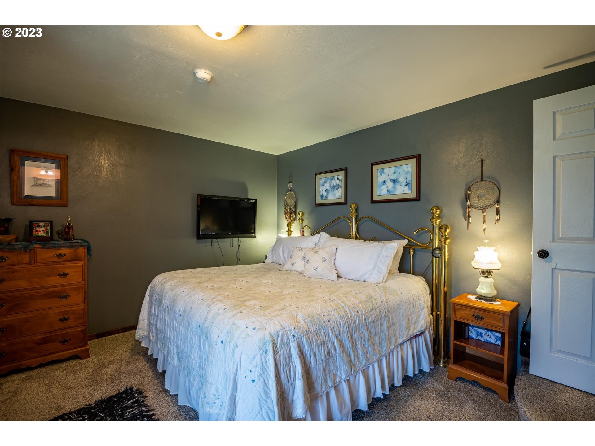 100 South 6th Street Lakeside, OR 97449 - Photo 10 of 42 a bedroom with a bed a mirror on dresser and a couch