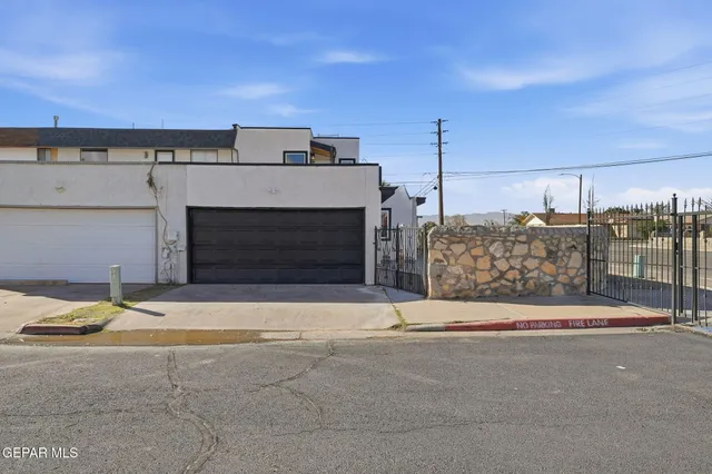 a view of building with garage and wooden fence