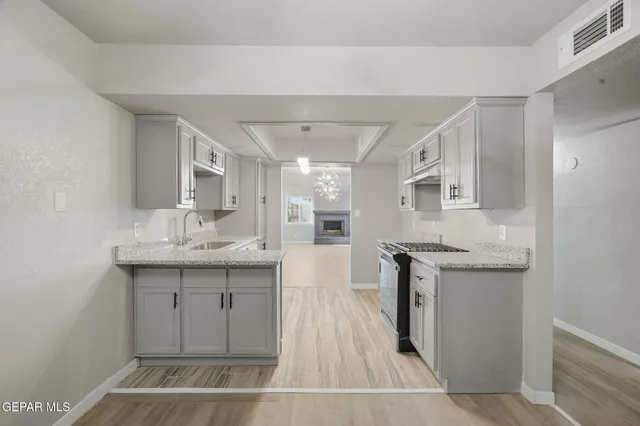 a kitchen with granite countertop a sink stainless steel appliances and cabinets