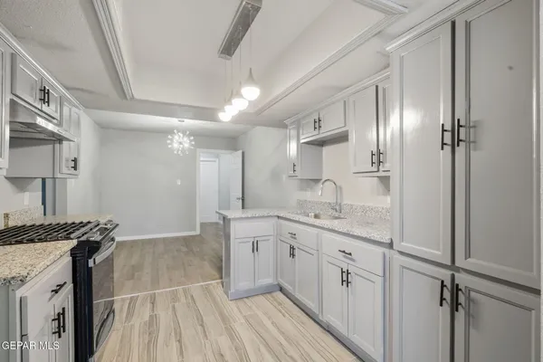 an empty room with chandelier fan and fireplace