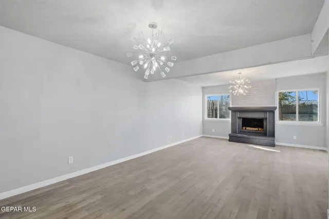 a view of an empty room with a fireplace and a window