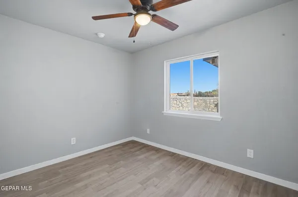 an empty room with a empty space and a ceiling fan
