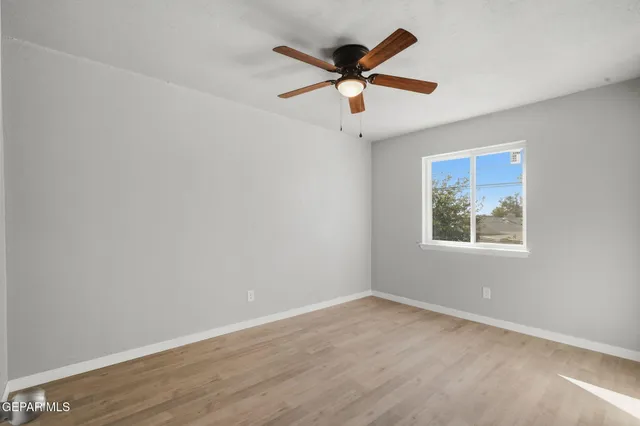 an empty room with closet and a ceiling fan