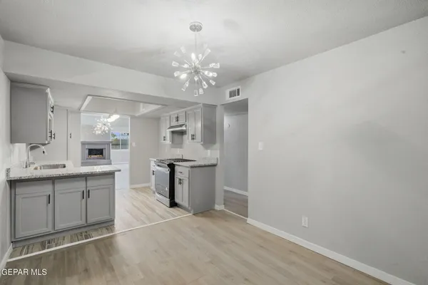 a view of a chandelier fan and hardwood floor