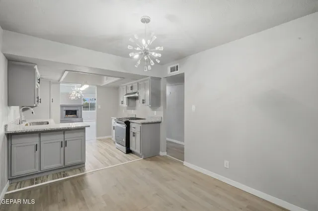 a view of a chandelier fan and hardwood floor