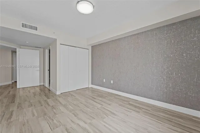 a view of an empty room with wooden floor