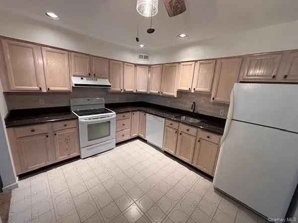 a kitchen with granite countertop a sink stainless steel appliances and cabinets