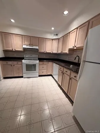 a kitchen with stainless steel appliances granite countertop a stove a sink and a refrigerator