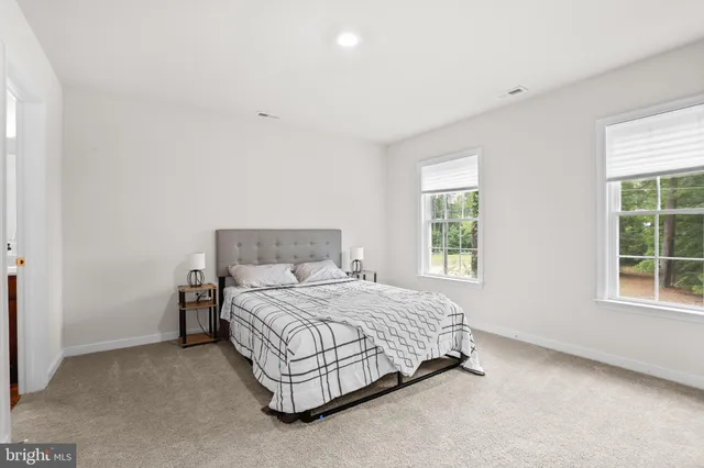 a bathroom with a granite countertop sink a toilet and mirror