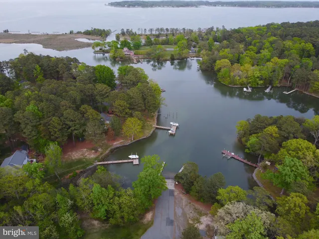 an aerial view of residential houses with outdoor space and lake view