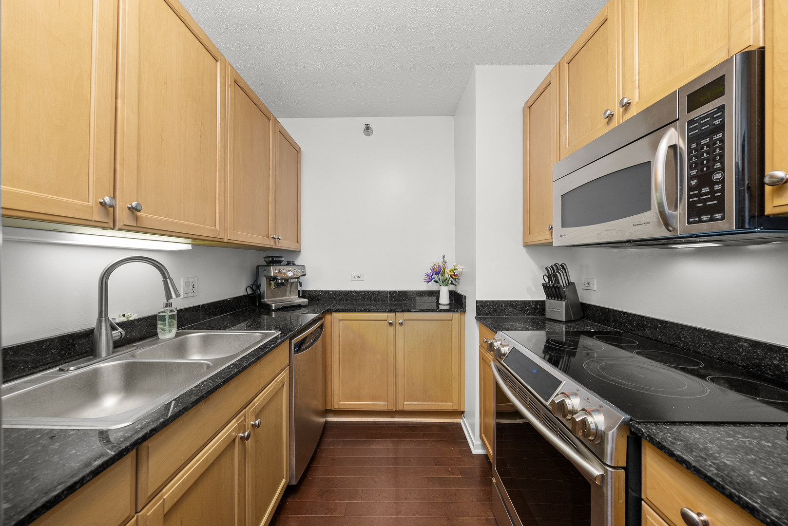 400 North LaSalle Drive, Unit 2002 Chicago, IL 60654 - Photo 7 of 30 a kitchen with granite countertop a sink a stove and cabinets