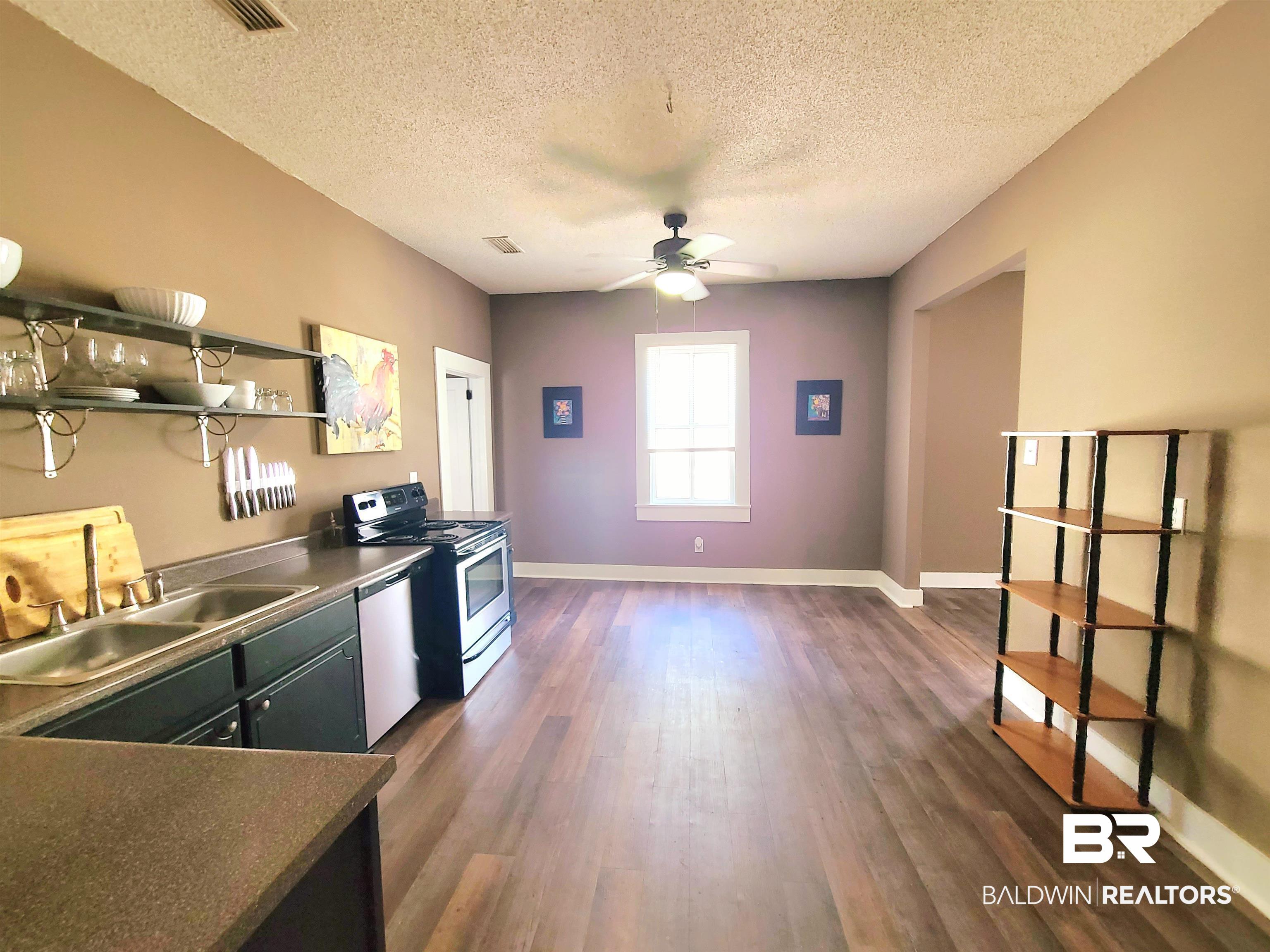112 Espejo Street Mobile, AL 36604 - Photo 6 of 20 Kitchen featuring stainless steel appliances, a sink, dark wood-style floors, a ceiling fan, and a textured ceiling