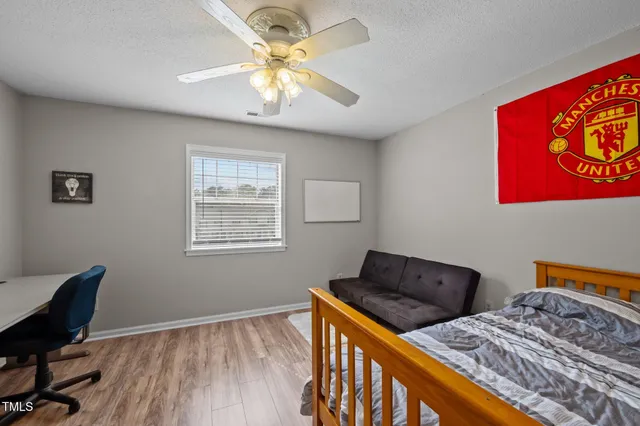 a bedroom with a bed and wooden floor