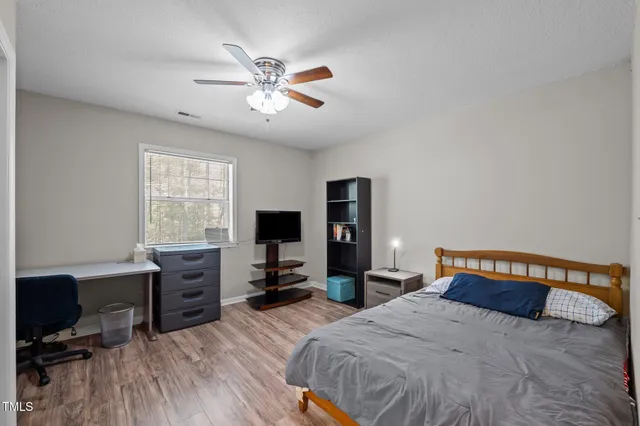 a bedroom with a bed and wooden floor