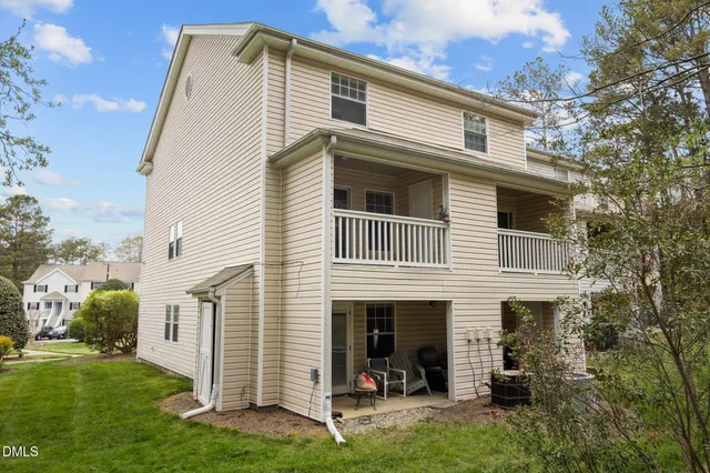 a front view of residential houses with yard and green space