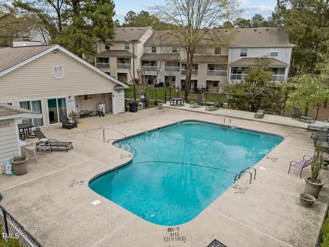a view of a white house with a big yard and large tree
