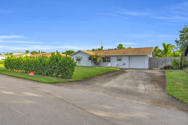 a view of a house with a yard and potted plants