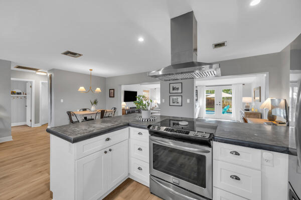 102 Pineview Road Jupiter, FL 33469 - Photo 11 of 34 a kitchen with stainless steel appliances granite countertop a stove and white cabinets