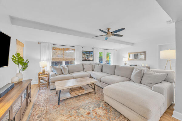 102 Pineview Road Jupiter, FL 33469 - Photo 14 of 34 a living room with furniture a ceiling fan a lamp and a window