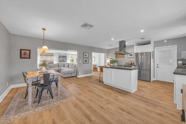 102 Pineview Road Jupiter, FL 33469 - Photo 4 of 34 a living room with stainless steel appliances kitchen island granite countertop furniture wooden floor and a kitchen view