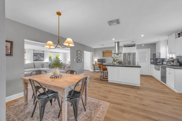 102 Pineview Road Jupiter, FL 33469 - Photo 5 of 34 a view of a dining room and livingroom with furniture wooden floor a chandelier