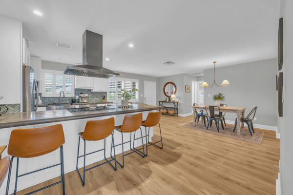 102 Pineview Road Jupiter, FL 33469 - Photo 10 of 34 a kitchen with stainless steel appliances granite countertop table chairs sink and cabinets