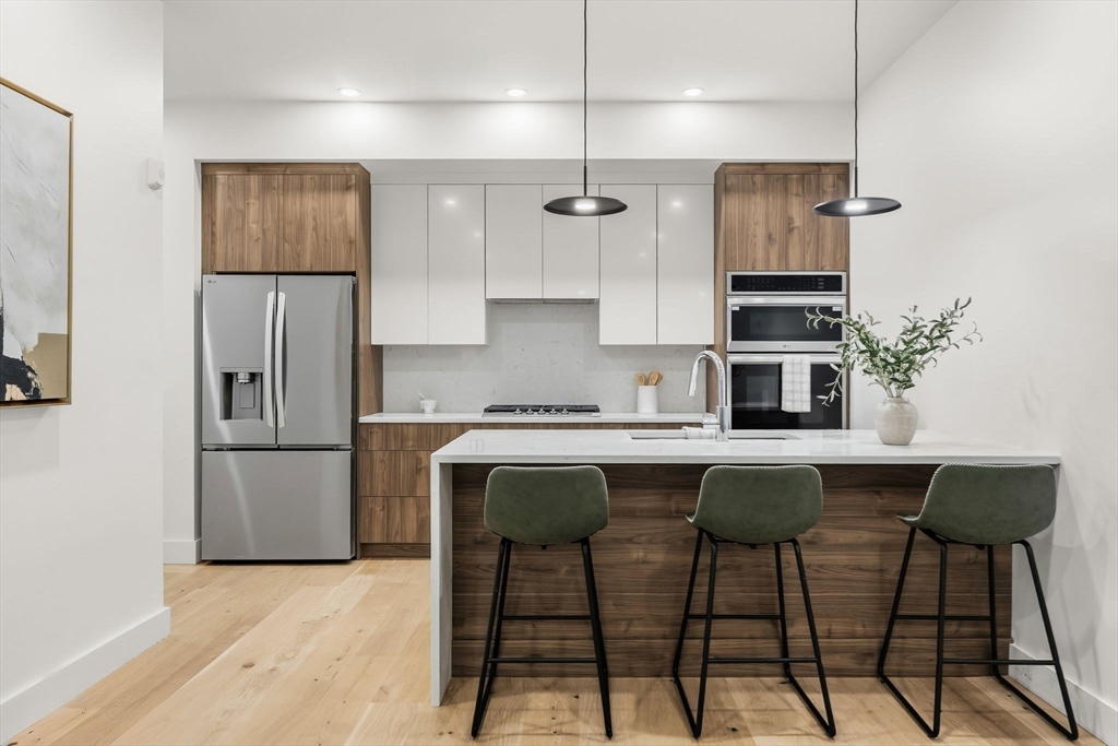 47 Condor Street, Unit 202 Boston, MA 02128 - Photo 3 of 17 a kitchen with stainless steel appliances a sink and a refrigerator