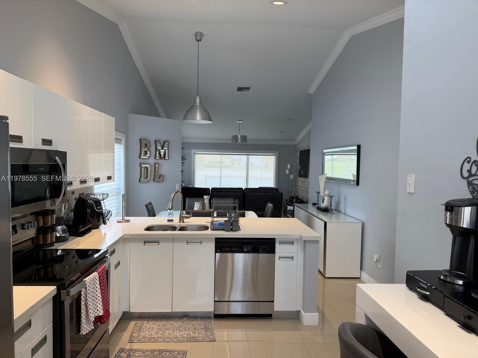 10285 Allegro Drive Boca Raton, FL 33428 - Photo 15 of 55 a kitchen that has a lot of cabinets a sink and a stove in it