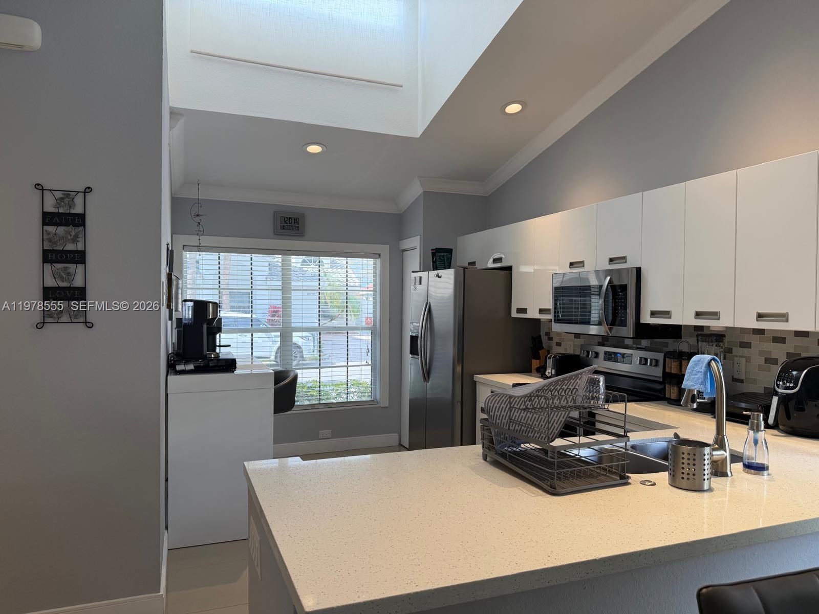 10285 Allegro Drive Boca Raton, FL 33428 - Photo 17 of 55 a room with furniture a flat screen tv and a view of kitchen