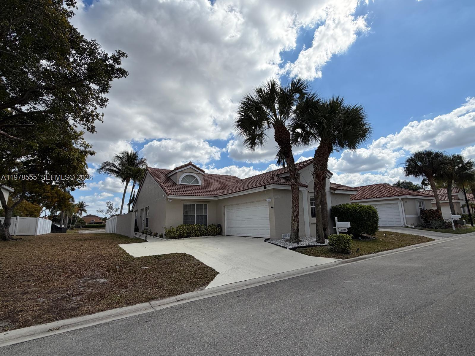 10285 Allegro Drive Boca Raton, FL 33428 - Photo 3 of 55 a front view of a house with a yard and garage