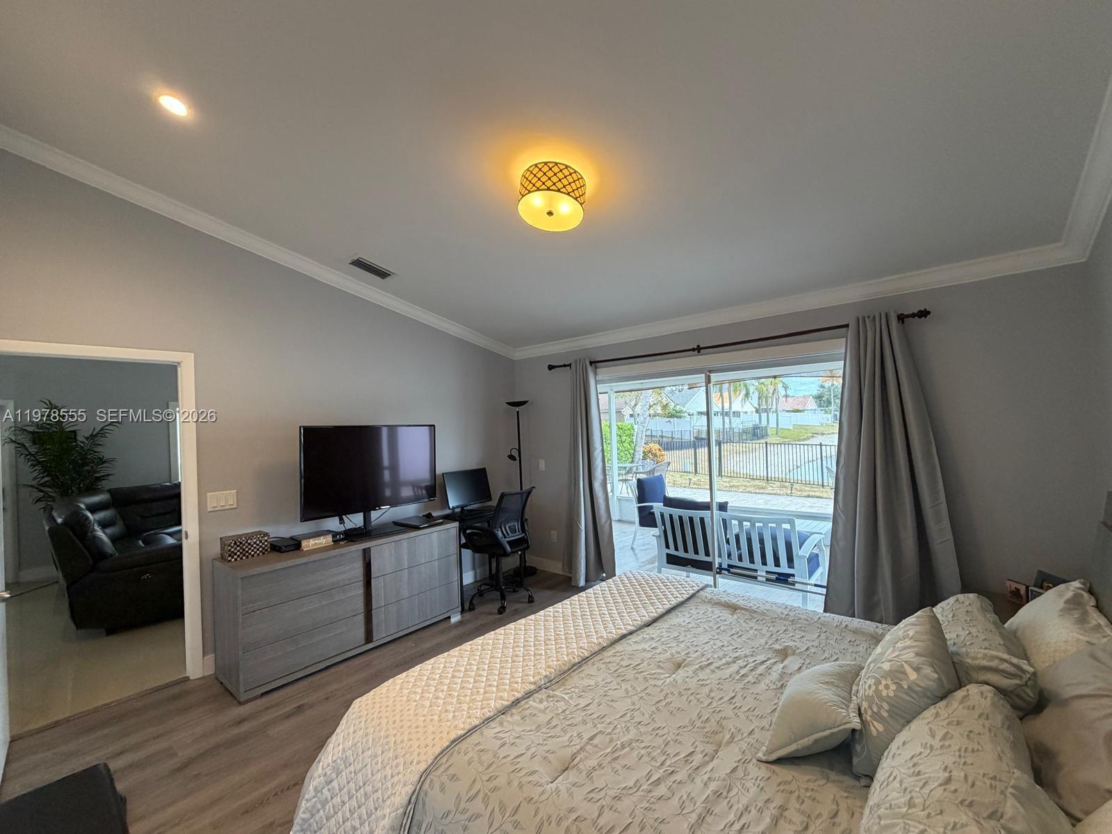 10285 Allegro Drive Boca Raton, FL 33428 - Photo 36 of 55 a bedroom with a bed and a flat tv screen on the dresser