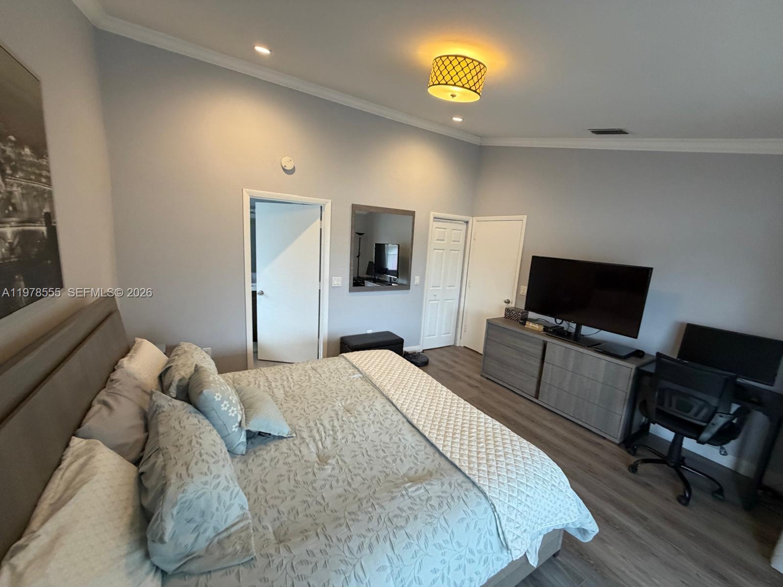 10285 Allegro Drive Boca Raton, FL 33428 - Photo 48 of 55 a bedroom with a bed and a flat screen tv